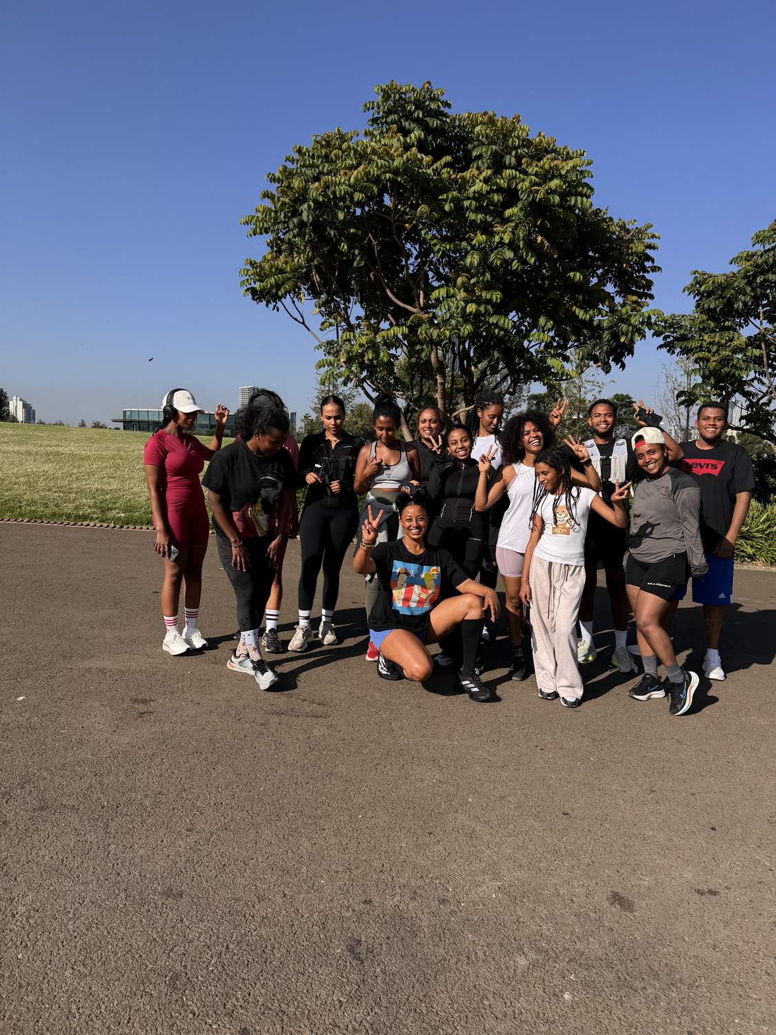 The crew posing under the trees at the park in the early morning sun